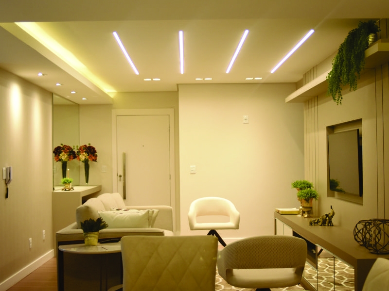 Sala de apartamento pequeno como iluminação decorativa amarela. Uma sala pequena com vários pontos de luz controlada. Criando  um ambiente acolhedor e aconchegante.